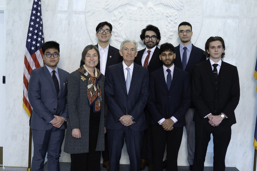 Group photo of Fed Chairman Powell standing with Stamford students and Professor Natalia Smirnova